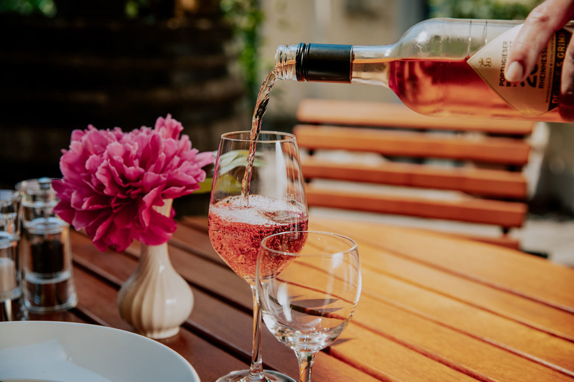 Rosewein wird in ein Glas eingeschenkt