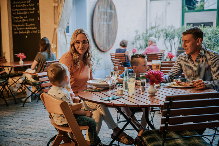 Familien mit Kindern beim Essen im Innenhof