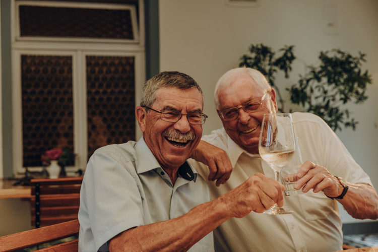 Zwei Männer stoßen mit Wein an
